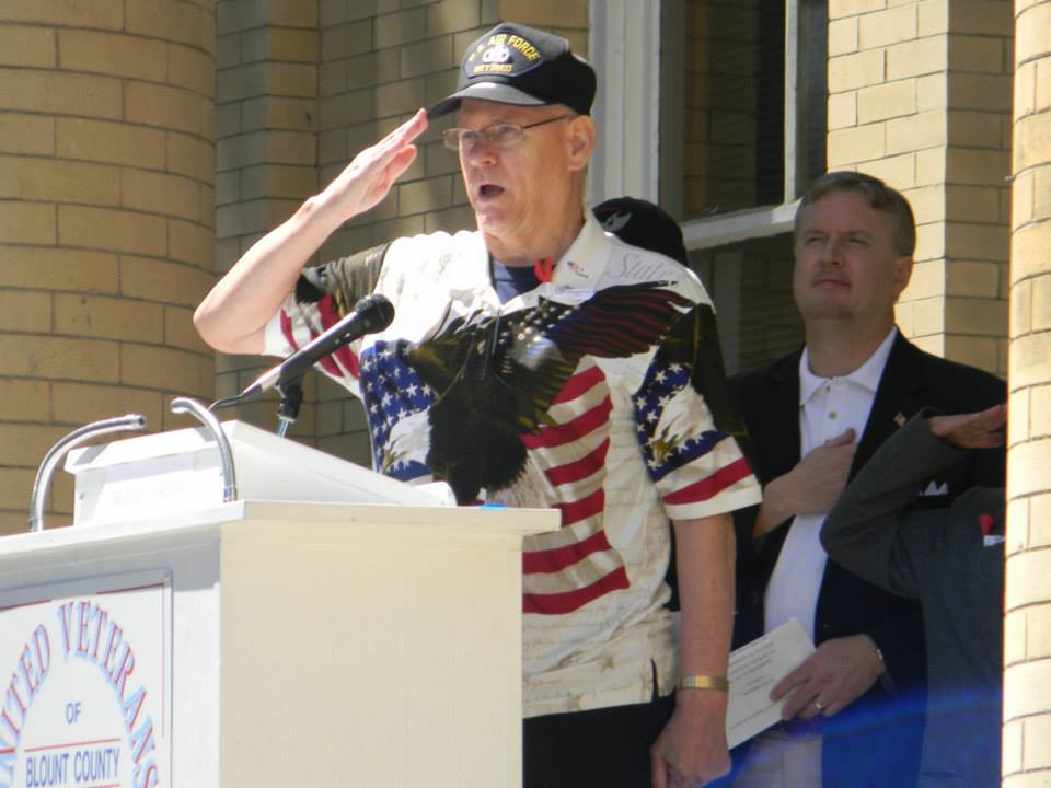 Man at podium saluting